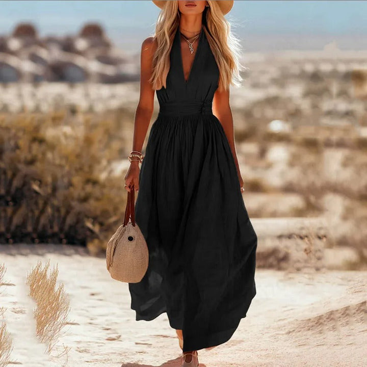 Women's halter maxi dress in brown and white with V-neck, sleeveless cut, and pleated skirt