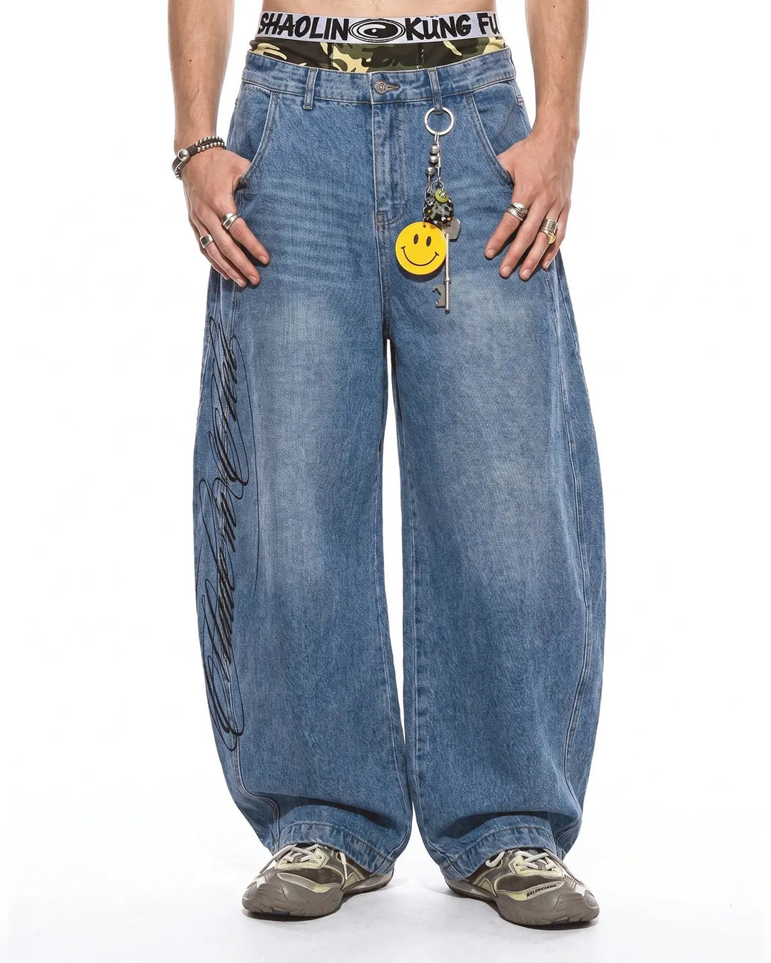 Light blue barrel jeans with dark script graphic on one leg