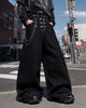 Black asymmetric denim overalls with buckle details and wide legs