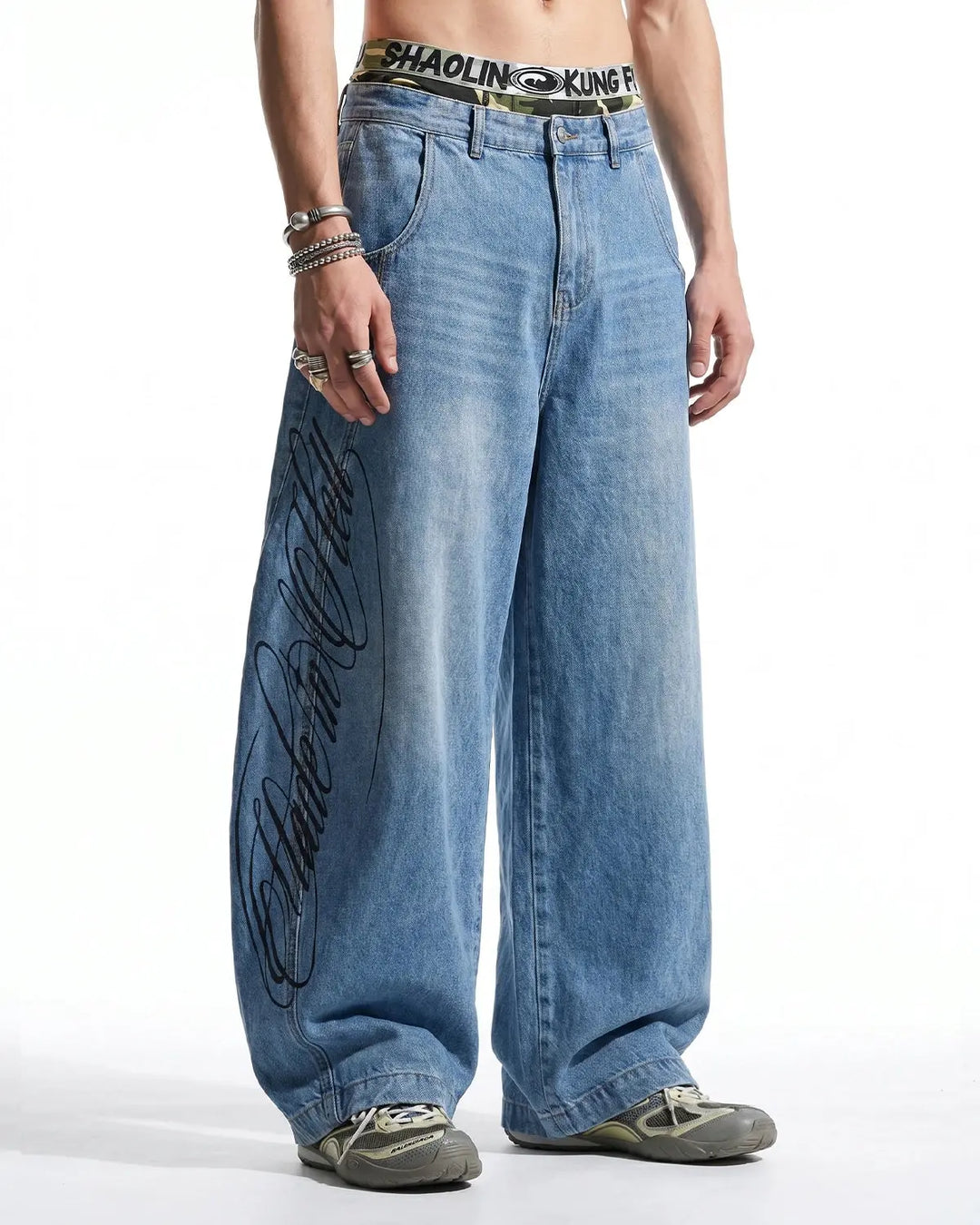 Light blue barrel jeans with dark script graphic on one leg