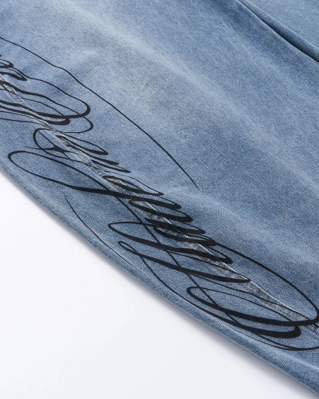 Light blue barrel jeans with dark script graphic on one leg