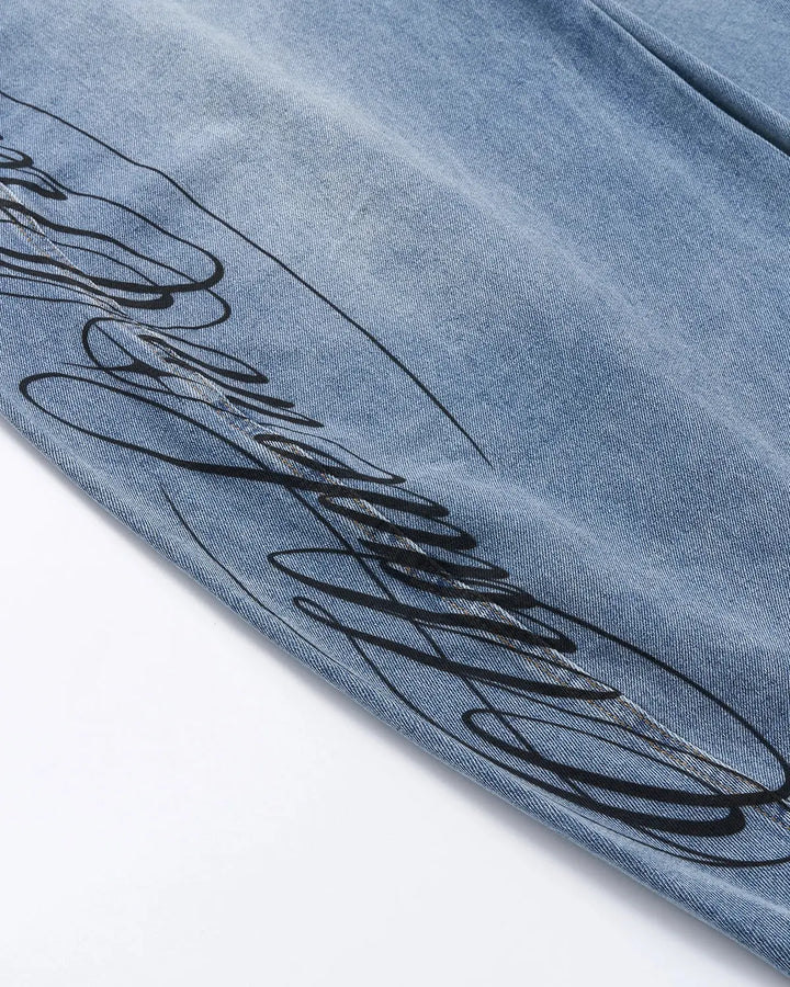 Light blue barrel jeans with dark script graphic on one leg