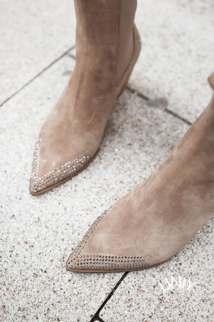 Women's beige pointed-toe western ankle boots with studded toes