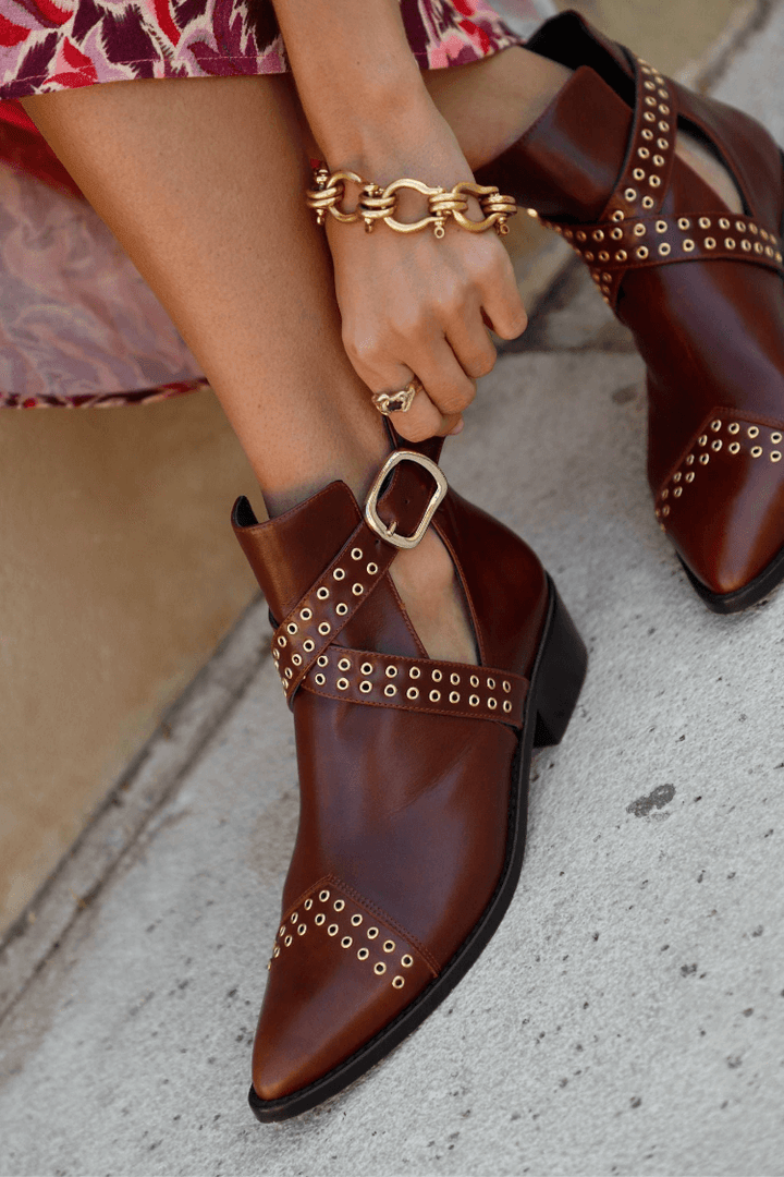 Women's brown pointed ankle boots with studded buckle straps