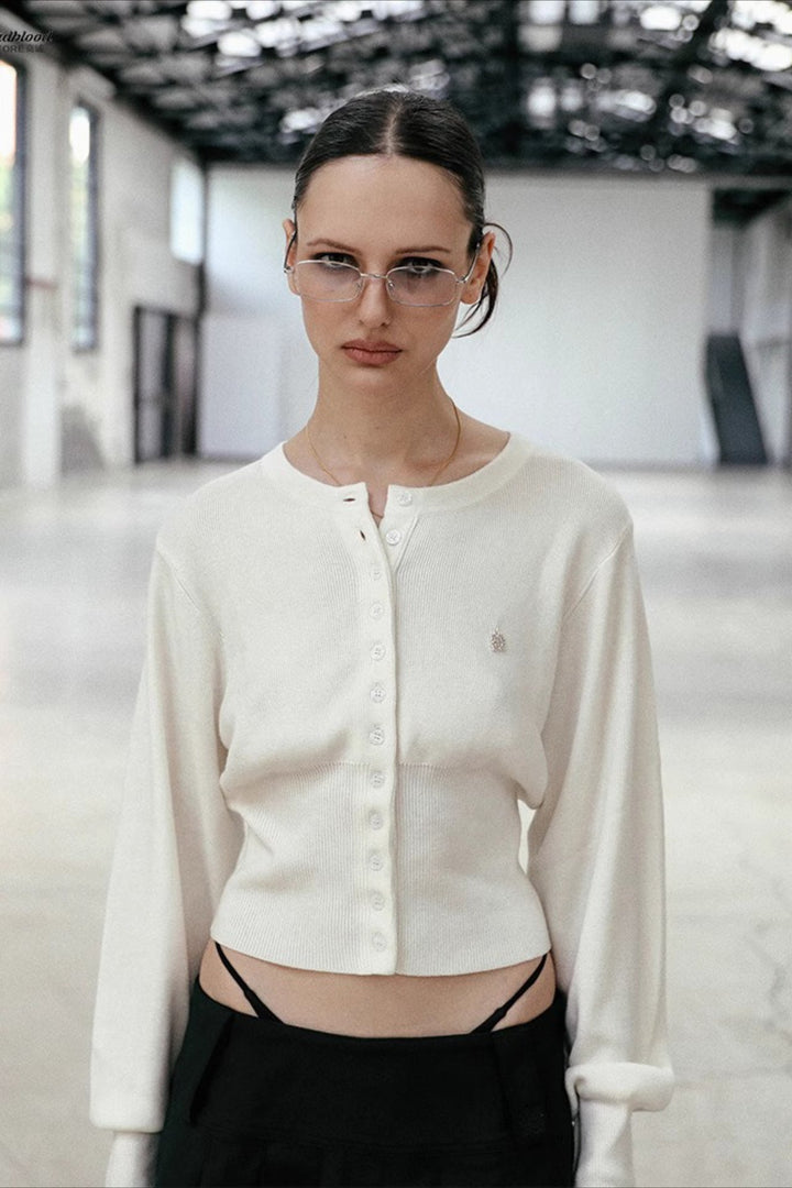 Women's cropped button cardigan with long sleeves and embroidered chest motif