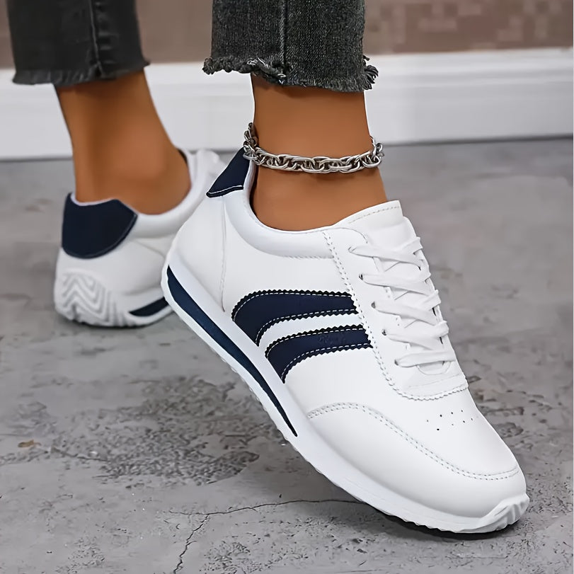 White lace-up trainers with navy side stripes and flat soles