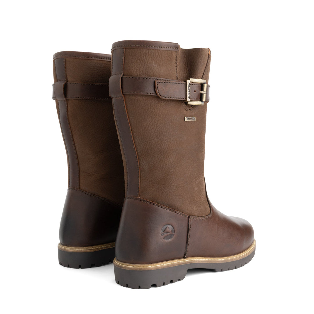 Brown tall outdoor boots with buckle straps and flat lug soles