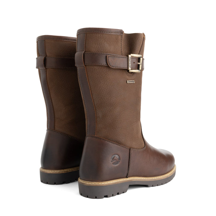 Brown tall outdoor boots with buckle straps and flat lug soles