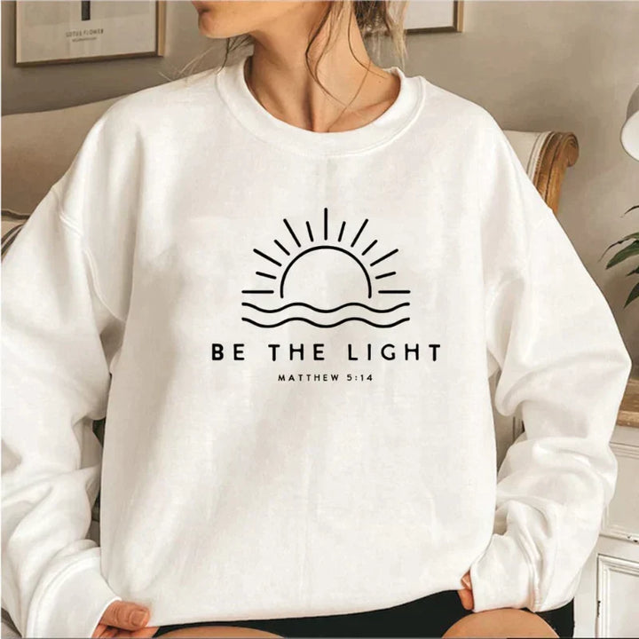 Women's crew neck sweatshirt with sun and wave graphic and Be The Light text