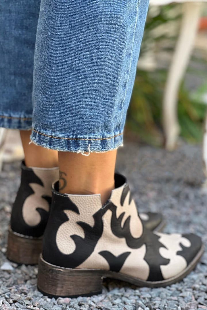 Black and cream patterned cutout ankle boots with pointed toes and low block heels