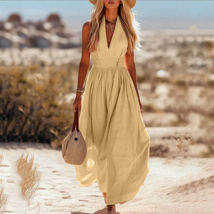 Women's halter maxi dress in brown and white with V-neck, sleeveless cut, and pleated skirt