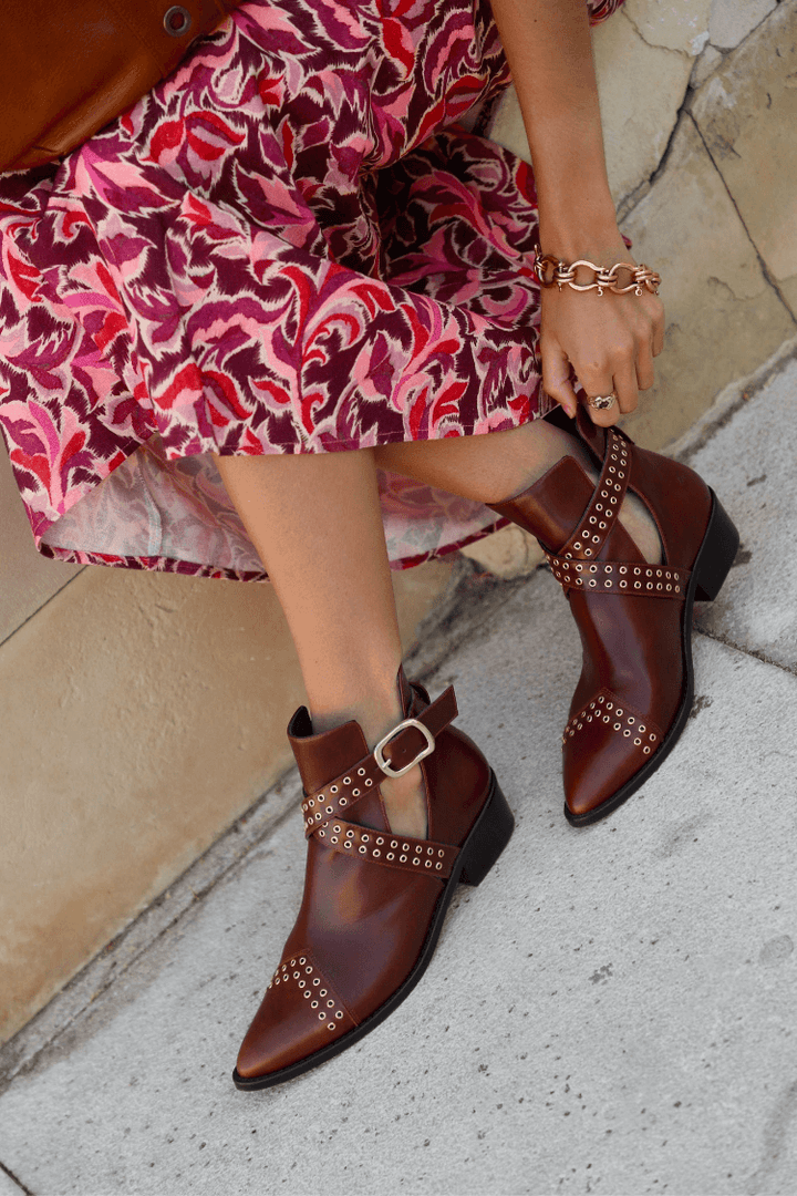 Women's brown pointed ankle boots with studded buckle straps