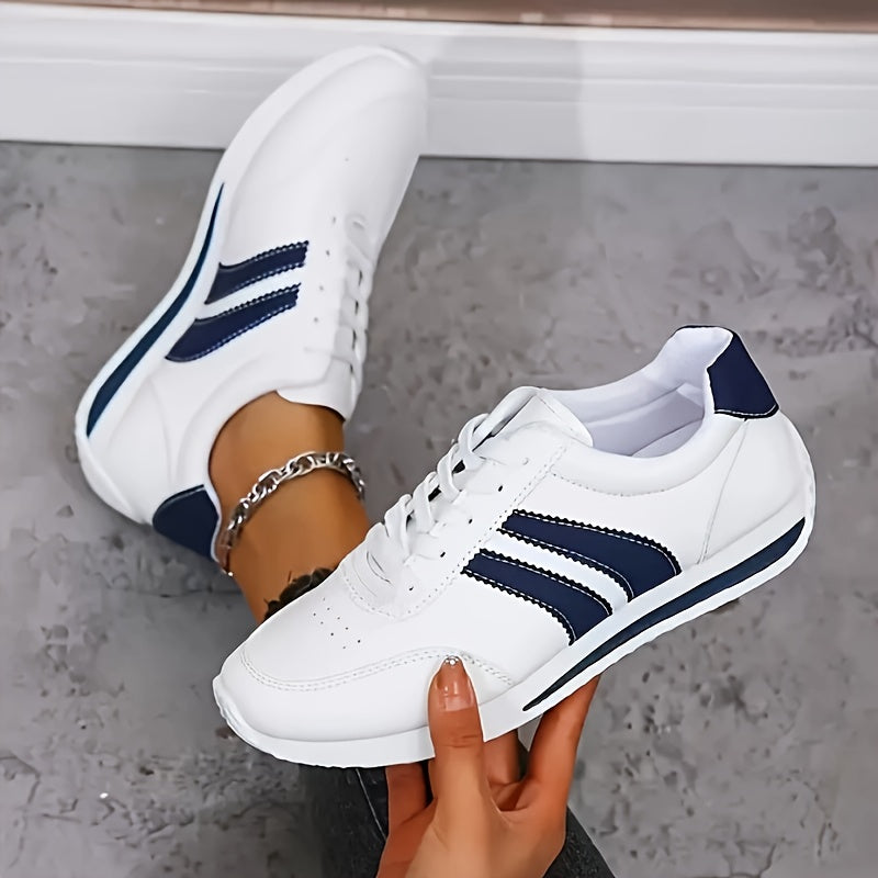 White lace-up trainers with navy side stripes and flat soles