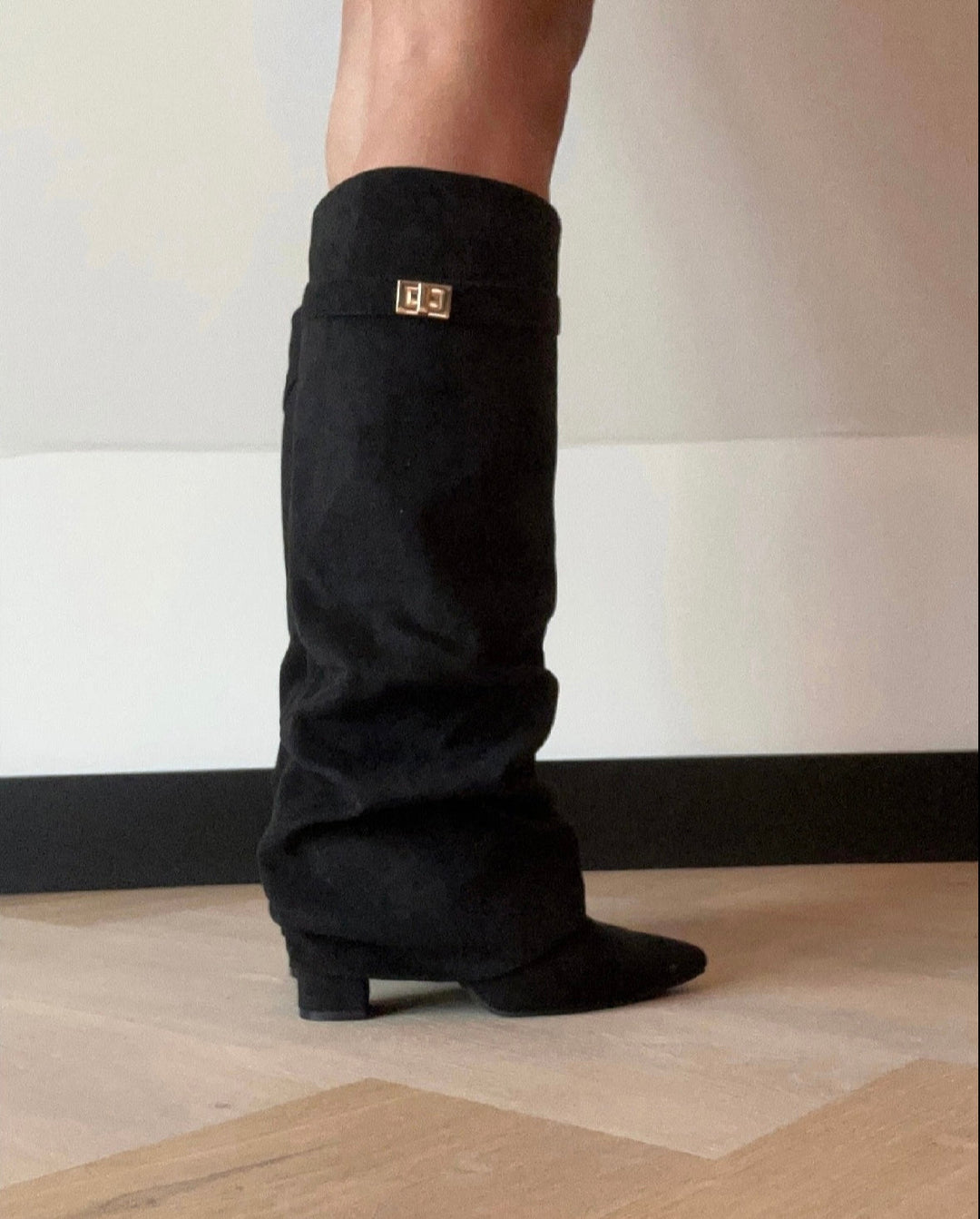 Black women's slouch knee-high boots with pointed toes, low heels and buckle trim