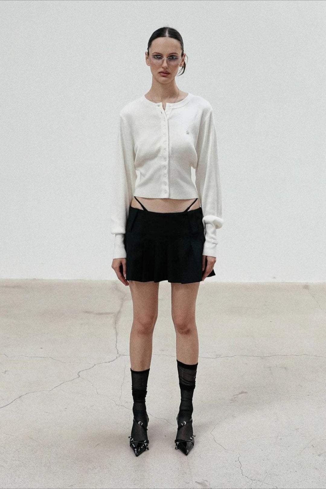 Women's cropped button cardigan with long sleeves and embroidered chest motif