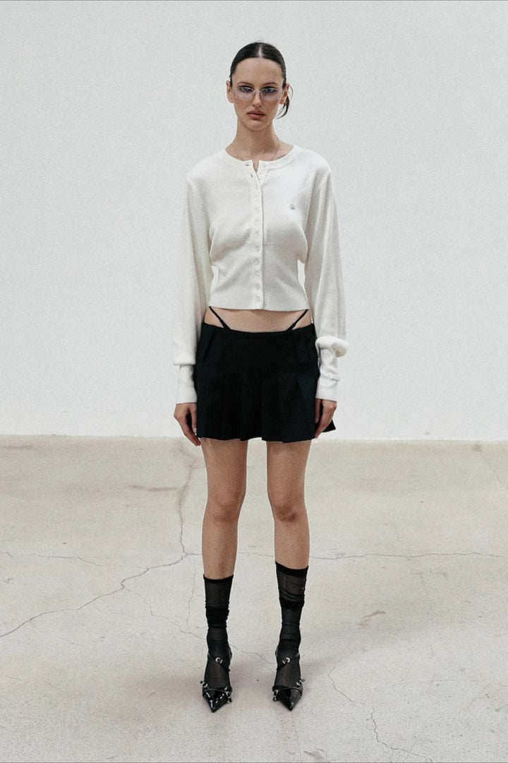 Women's cropped button cardigan with long sleeves and embroidered chest motif
