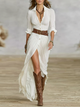 Women's pleated white maxi dress with deep V-neckline, long sleeves, belt and asymmetrical side-split hem