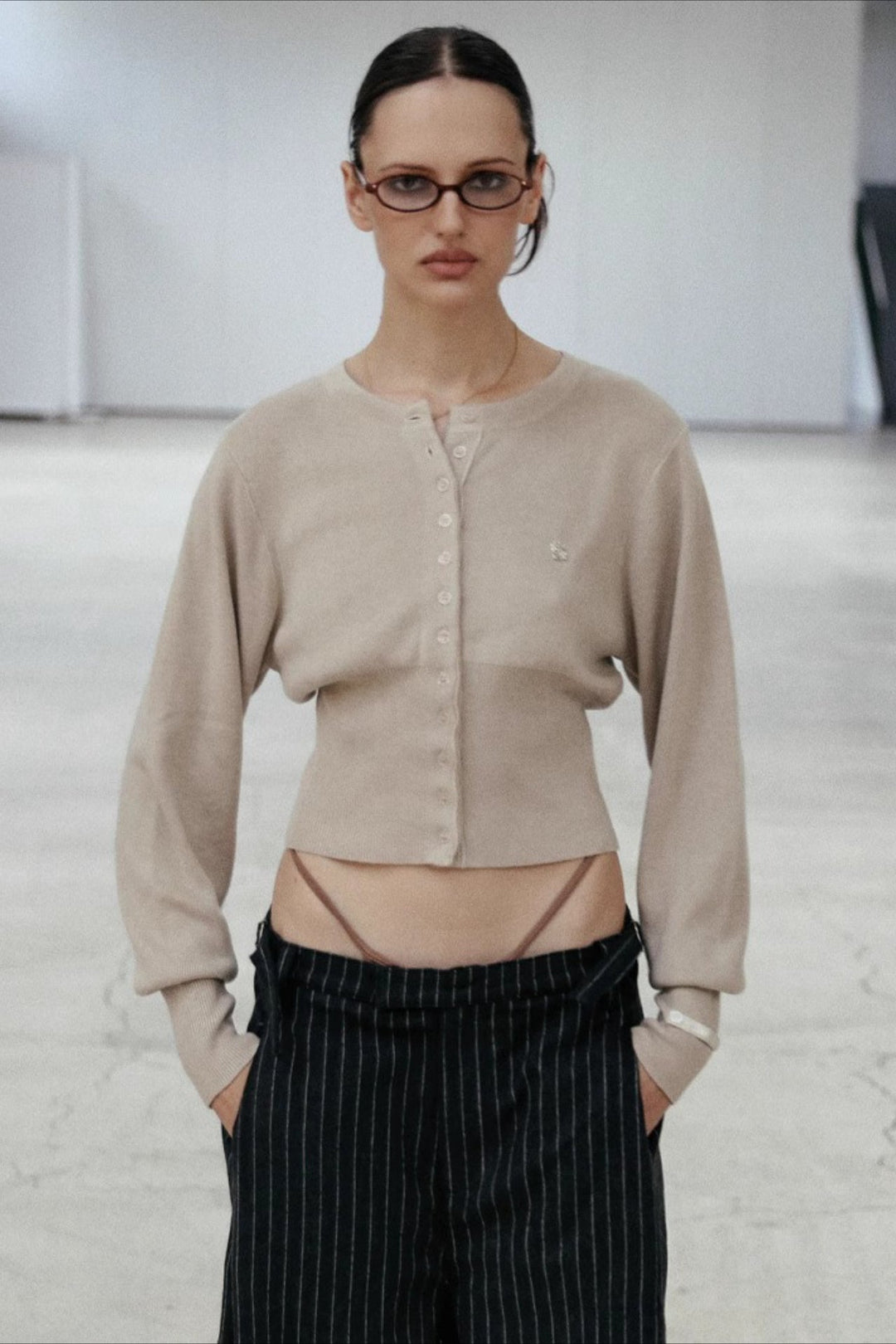 Women's cropped button cardigan with long sleeves and embroidered chest motif