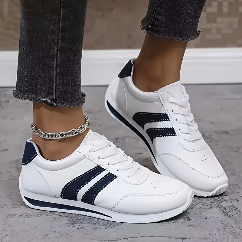 White lace-up trainers with navy side stripes and flat soles