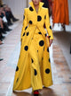Yellow long coat with large black polka dots