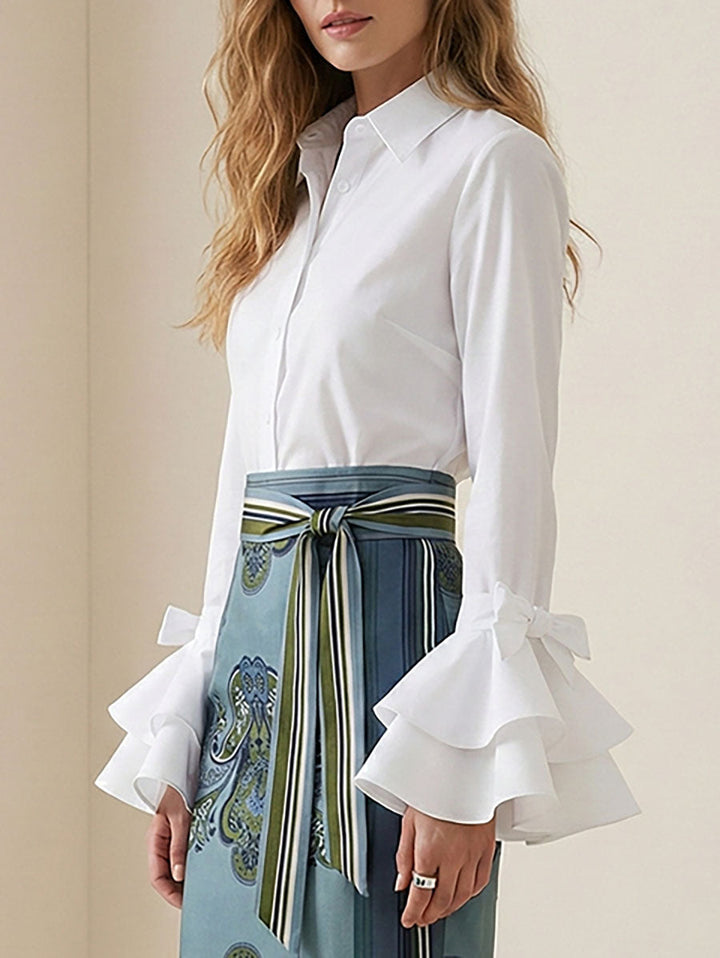 Women's solid blouse with raised collar, long sleeves, bow details and layered ruffle cuffs