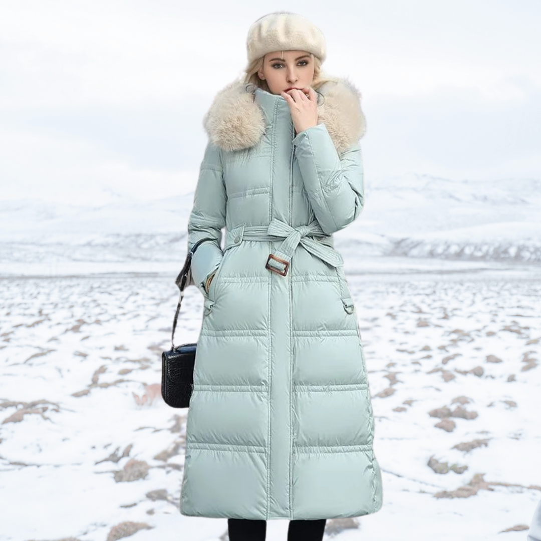 Women's longline quilted coat with fur-effect collar in a snowy outdoor setting
