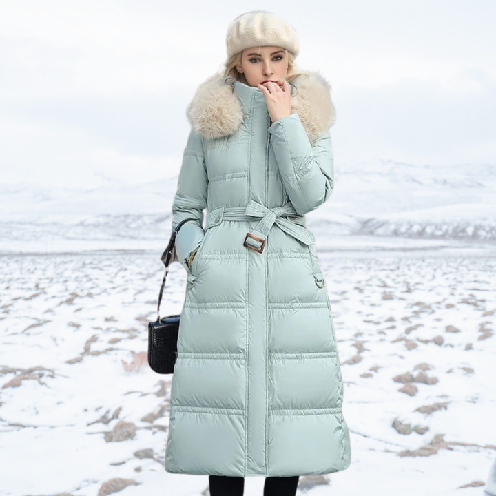 Women's longline quilted coat with fur-effect collar in a snowy outdoor setting
