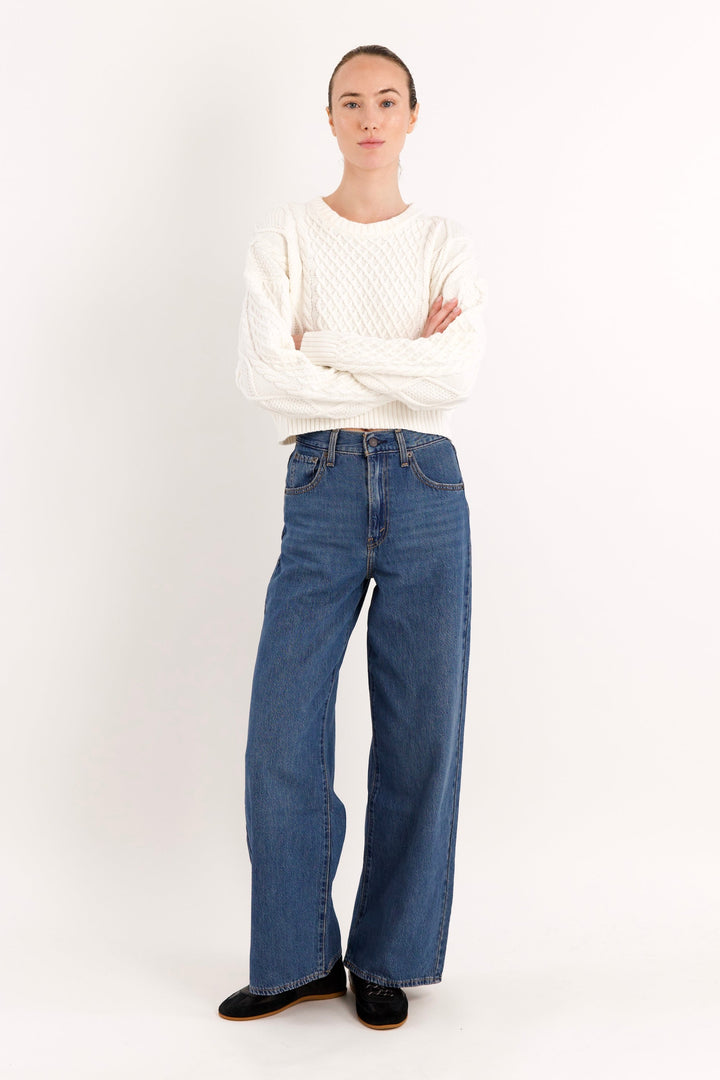 Women's cropped cable knit sweater with crew neckline and long sleeves