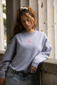 Women's light grey crewneck sweatshirt with pink chest logo and long sleeves