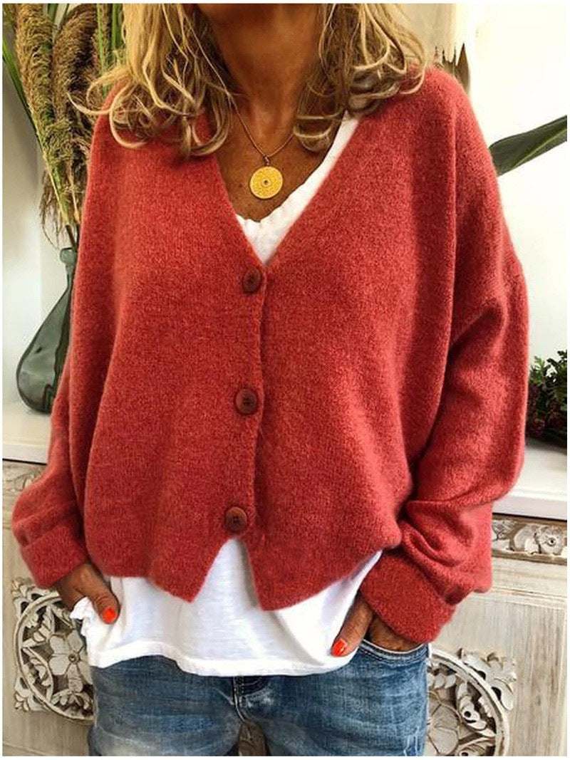 Women's long-sleeve V-neck button front cardigan layered over a white top and jeans