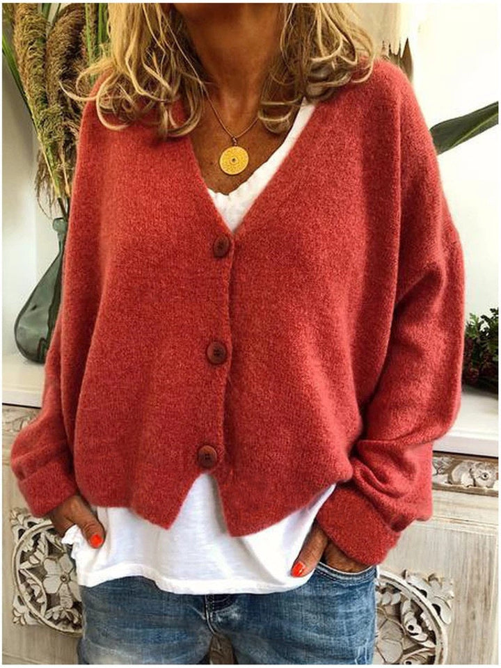 Women's long-sleeve V-neck button front cardigan layered over a white top and jeans