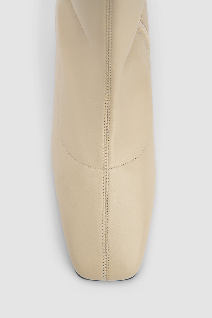 Women's beige pointed toe ankle boot with side zipper and low block heel