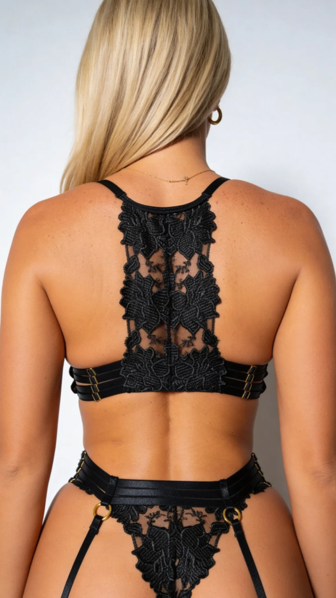 Women's black lace four-piece lingerie set with bra, briefs, garter belt and stockings