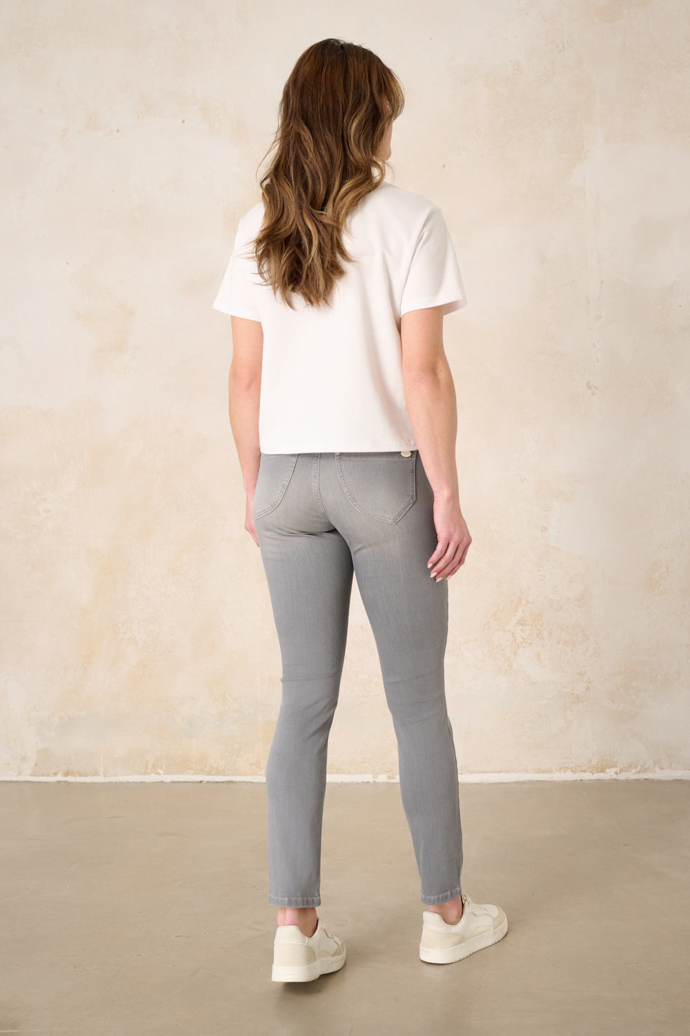 Women's grey slim fit jeans with a mid-rise waist and ankle-length legs