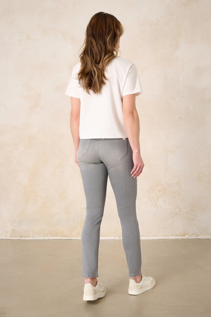 Women's grey slim fit jeans with a mid-rise waist and ankle-length legs