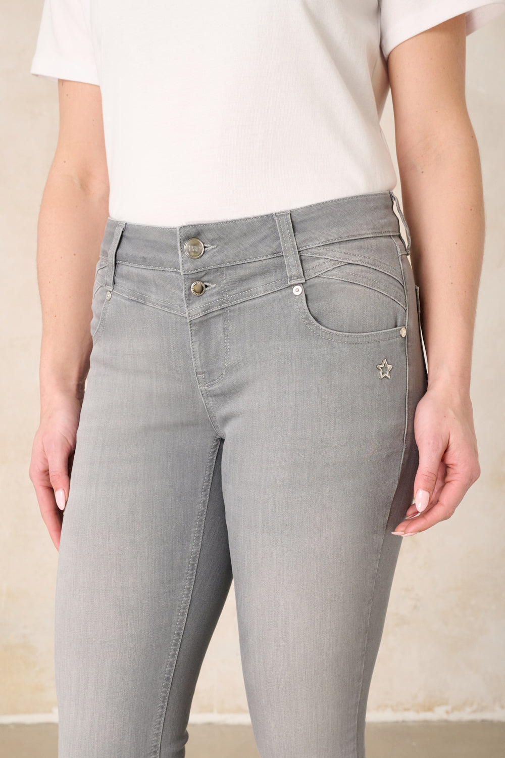 Women's grey slim fit jeans with a mid-rise waist and ankle-length legs