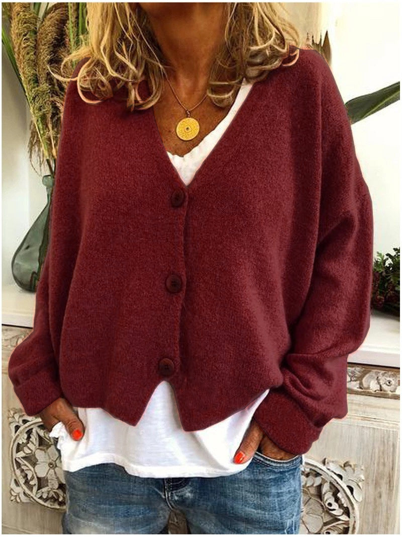 Women's long-sleeve V-neck button front cardigan layered over a white top and jeans