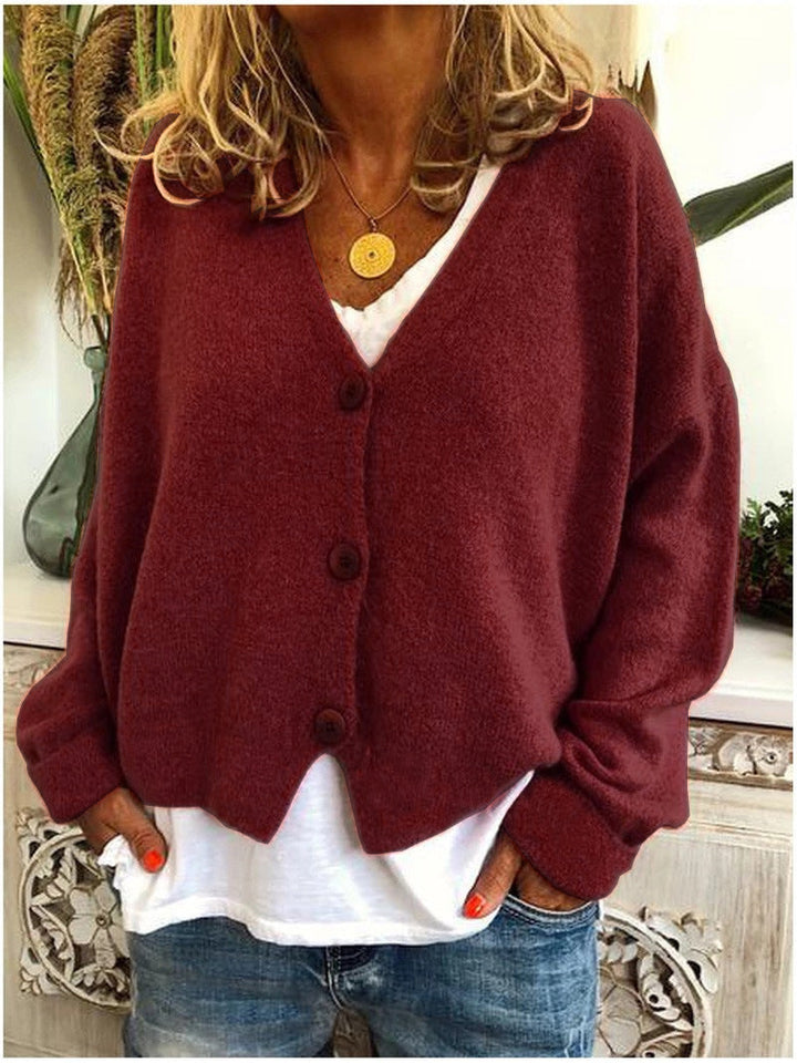 Women's long-sleeve V-neck button front cardigan layered over a white top and jeans