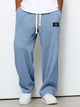 Men's blue waffle relaxed trousers with drawstring waist, shown worn with white trainers.