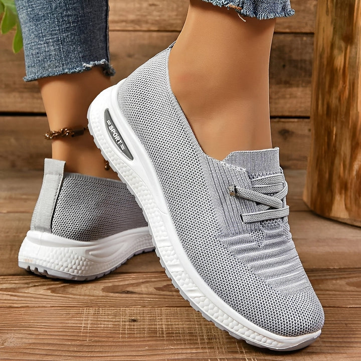 Women's grey lace-up sneakers with round toes and white flat soles