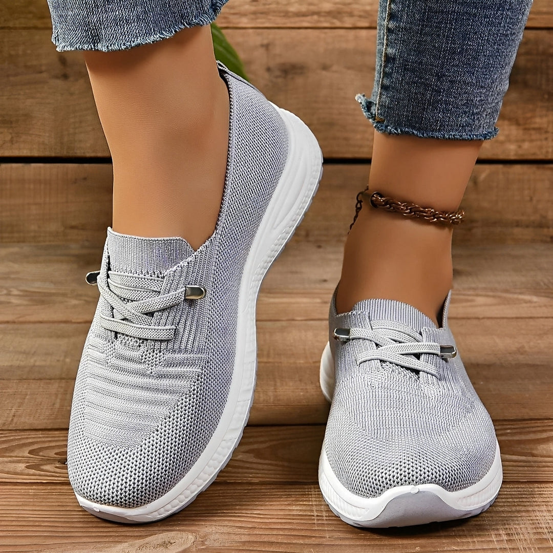 Women's grey lace-up sneakers with round toes and white flat soles