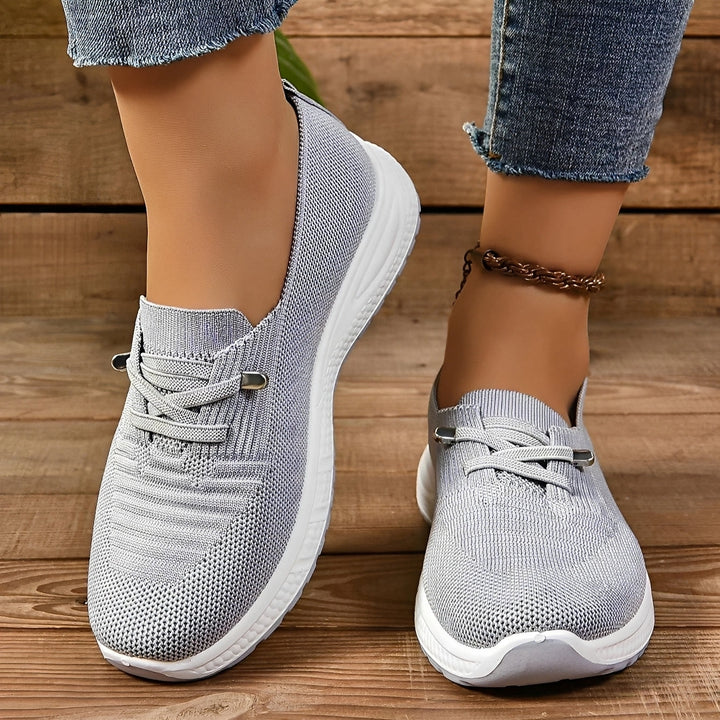 Women's grey lace-up sneakers with round toes and white flat soles