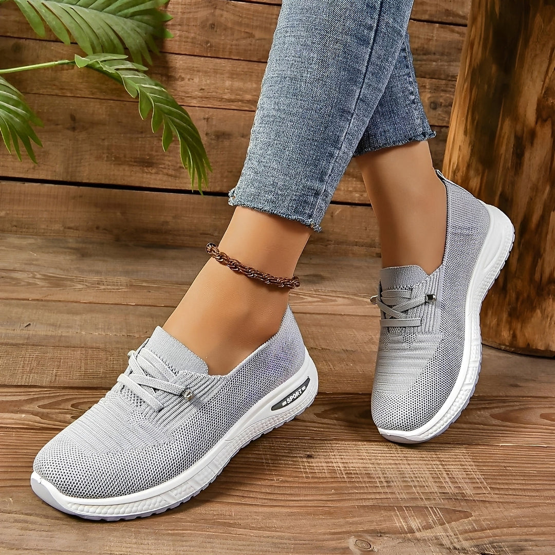Women's grey lace-up sneakers with round toes and white flat soles