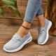 Women's grey lace-up sneakers with round toes and white flat soles