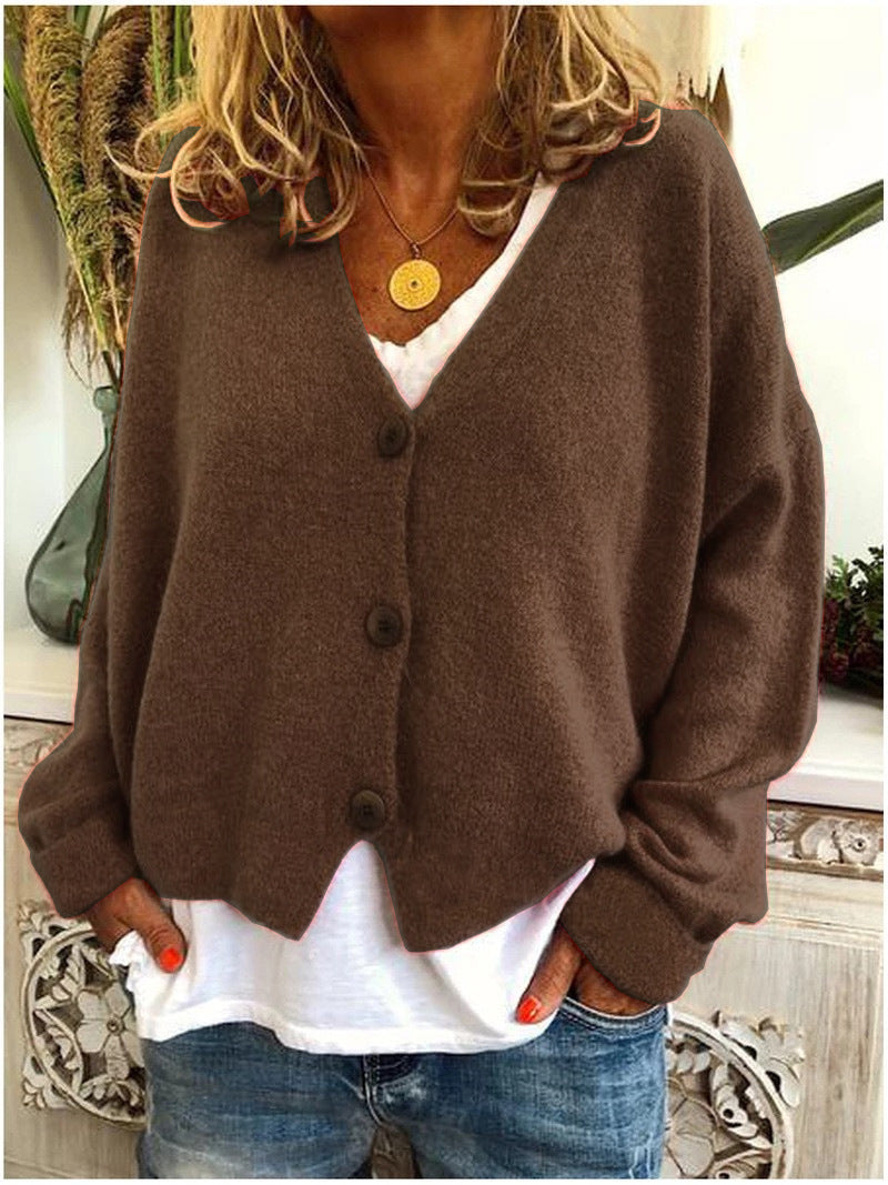 Women's long-sleeve V-neck button front cardigan layered over a white top and jeans