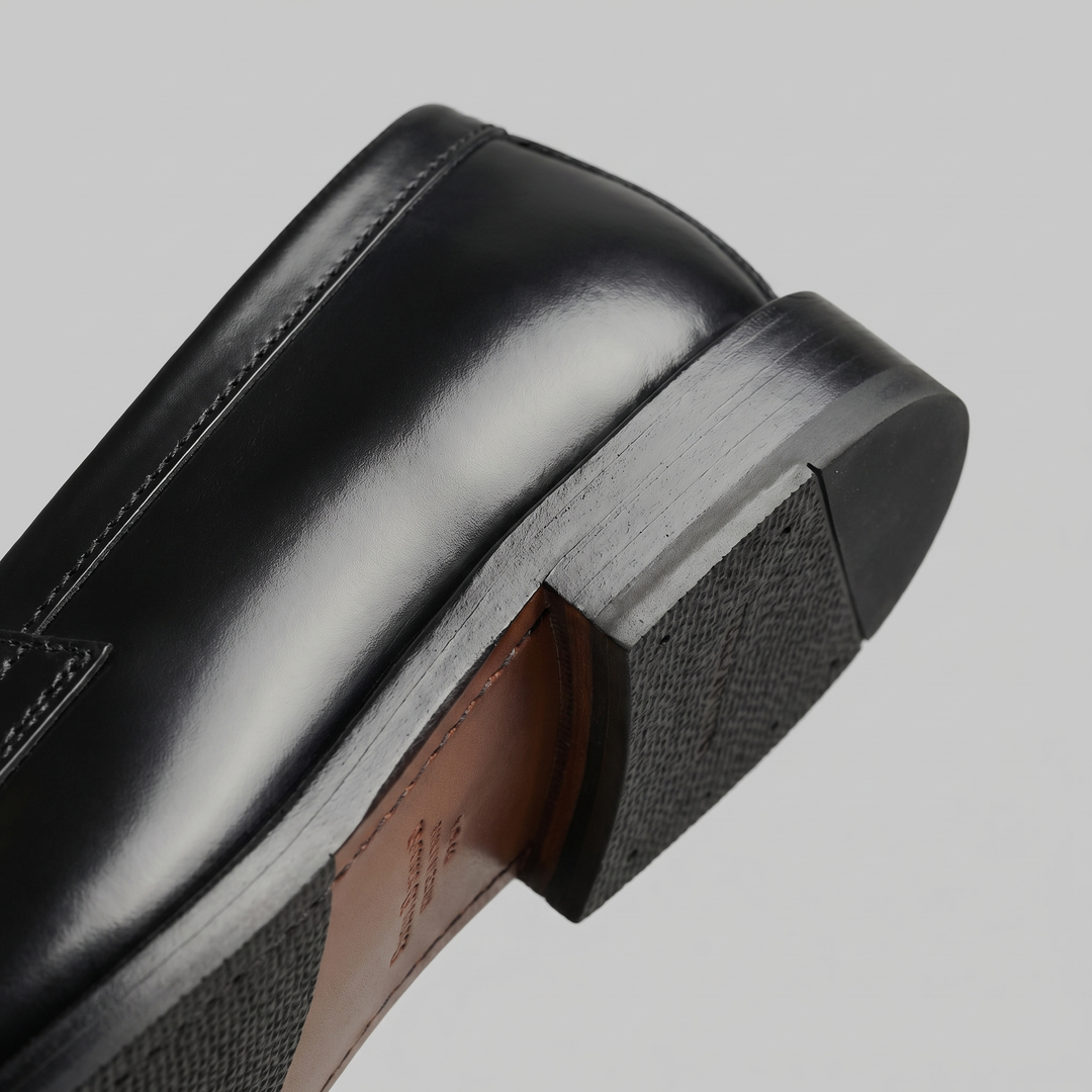 Men's black glossy penny loafers with rounded toes and low heels