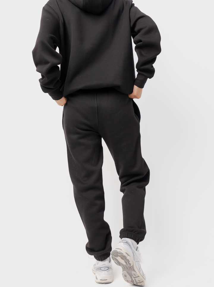 Women's black fleece jogger pants with logo detail and cuffed hems