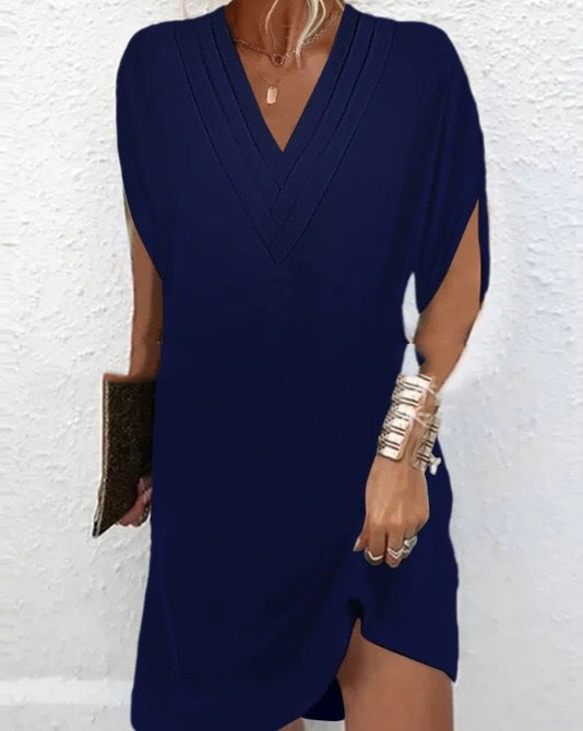 Women's wrap dress with deep V-neckline, short sleeves, and asymmetric hemline in green and blue.