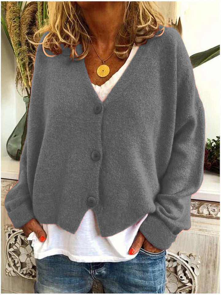 Women's long-sleeve V-neck button front cardigan layered over a white top and jeans