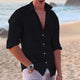 Men's long sleeve button-front shirt in white and black, shown on beach, worn open with relaxed fit.